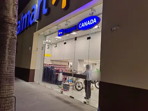 Fachada exterior de noche con rótulo Coppel Canadá