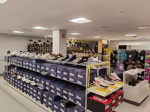 Piso de ventas: muro de calzado deportivo en exhibidores azules