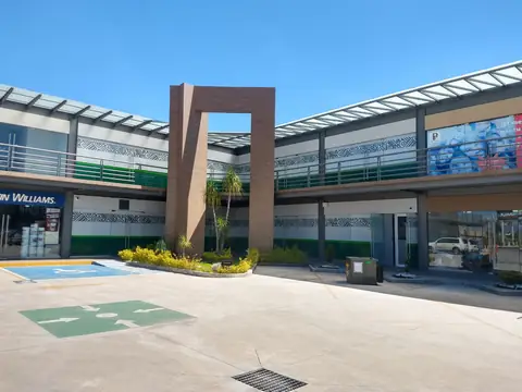Plaza comercial con arco de acceso y patio