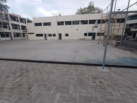 Patio y edificios del campus con andamio al fondo